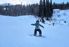 Kid snowboaring on Grom Burton Snowboard with Step Ons